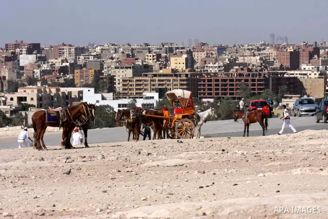 Foreign tourists ride horses and Rockaway near the Giza Pyramids at the outskirts of Cairo, capital of Egypt. in this picture taken May 11, 2011. Photo by Ashraf Amra