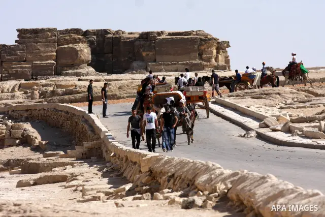 Foreign tourists ride horses and Rockaway and walk near the Giza Pyramids at the outskirts of Cairo, capital of Egypt. in this picture taken May 11, 2011. Photo by Ashraf Amra