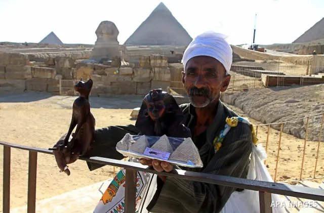Egyptian man holds ancient relics of the Pharaonic civilization in near the Giza Pyramids at the outskirts of Cairo, capital of Egypt. in this picture taken May 11, 2011. Photo by Ashraf Amra