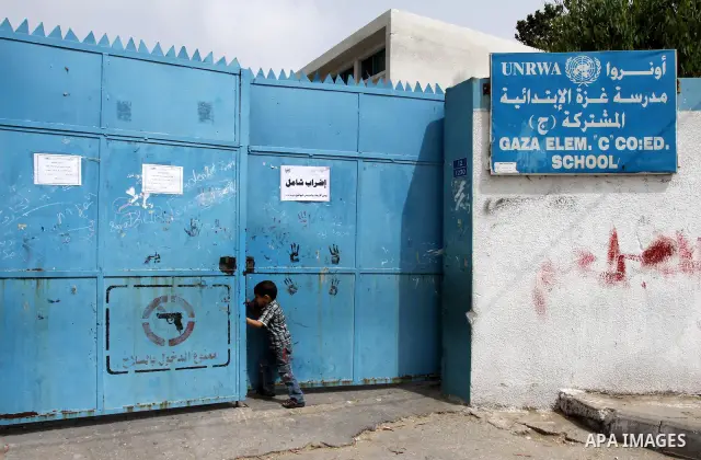 Palestinian boy stands in front of United Nations Relief and Works Agency (UNRWA) closed school in Gaza City May 18, 2011 as UN Palestinian employees stage a one day-strike demanding higher wages. Some 16 thousand Palest...