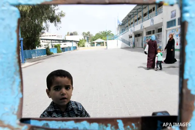 Palestinian boy stands in front of United Nations Relief and Works Agency (UNRWA) closed school in Gaza City May 18, 2011 as UN Palestinian employees stage a one day-strike demanding higher wages. Some 16 thousand Palest...