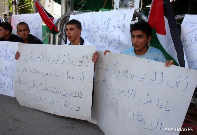 Palestinian youths hold placards during a rally in the West Bank city of Ramallah, May 19,2011 calling the U.S president Barack Obama to release the prisoners in Israeli jails and to return the Palestinian refugees from...