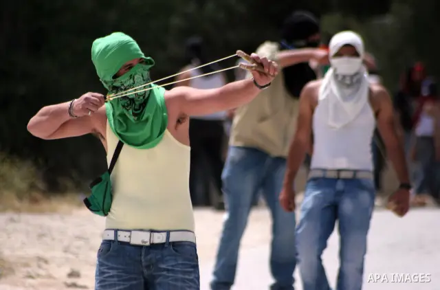 Masked Palestinian demonstrators hurl stones toward Israeli soldiers during a demonstration in the West Bank village of Al-khader near Bethlehem, Friday, May 20, 2011. President Barack Obama on Thursday finally uttered t...