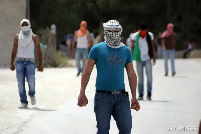 Masked Palestinian demonstrators hurl stones toward Israeli soldiers during a demonstration in the West Bank village of Al-khader near Bethlehem, Friday, May 20, 2011. President Barack Obama on Thursday finally uttered t...