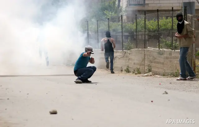 Masked Palestinian demonstrators hurl stones toward Israeli soldiers during a demonstration in the West Bank village of Al-khader near Bethlehem, Friday, May 20, 2011. President Barack Obama on Thursday finally uttered t...