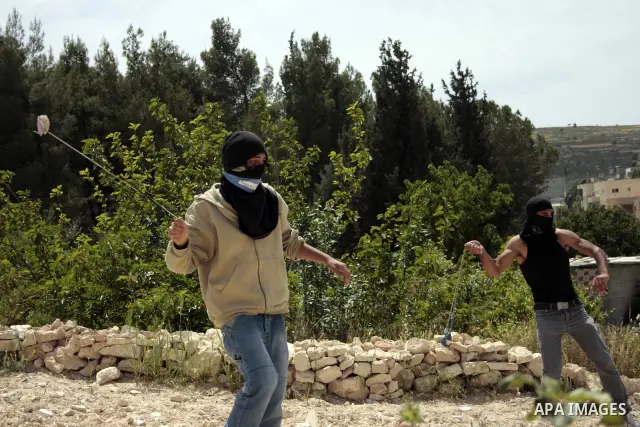 Masked Palestinian demonstrators hurl stones toward Israeli soldiers during a demonstration in the West Bank village of Al-khader near Bethlehem, Friday, May 20, 2011. President Barack Obama on Thursday finally uttered t...