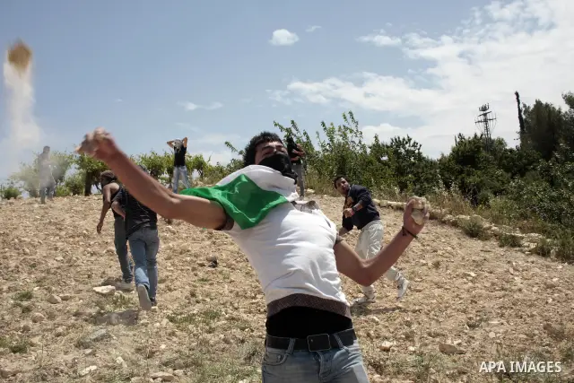 Masked Palestinian demonstrators hurl stones toward Israeli soldiers during a demonstration in the West Bank village of Al-khader near Bethlehem, Friday, May 20, 2011. President Barack Obama on Thursday finally uttered t...