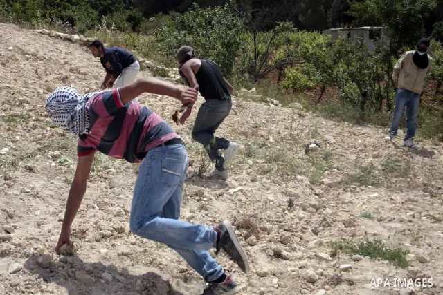 Masked Palestinian demonstrators hurl stones toward Israeli soldiers during a demonstration in the West Bank village of Al-khader near Bethlehem, Friday, May 20, 2011. President Barack Obama on Thursday finally uttered t...