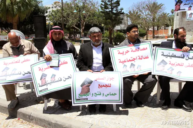 Palestinian protesters hold banners during an effectiveness to prevent them from obtaining passports by Ramallah, in Gaza city on May 21, 2011. Palestinians condemn it , and raise slogans against the political partisansh...