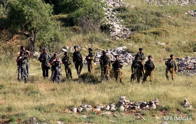 Israeli soldiers stand guard during a demonstration by Palestinian and foreign protesters against Jewish settlements in the northern West Bank village of Iraq Burin, near Nablus, Saturday, May 21, 2011. Photo by Wagdi Es...