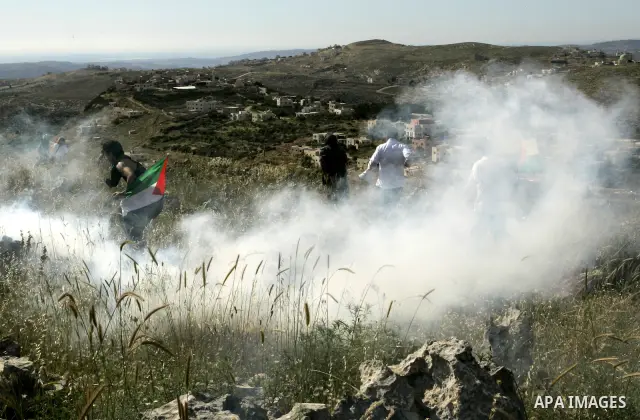 Palestinian and foreign protesters run from tear gas fired by Israeli soldiers, during a demonstration against Jewish settlements in the northern West Bank village of Iraq Burin, near Nablus, Saturday, May 21, 2011. Phot...