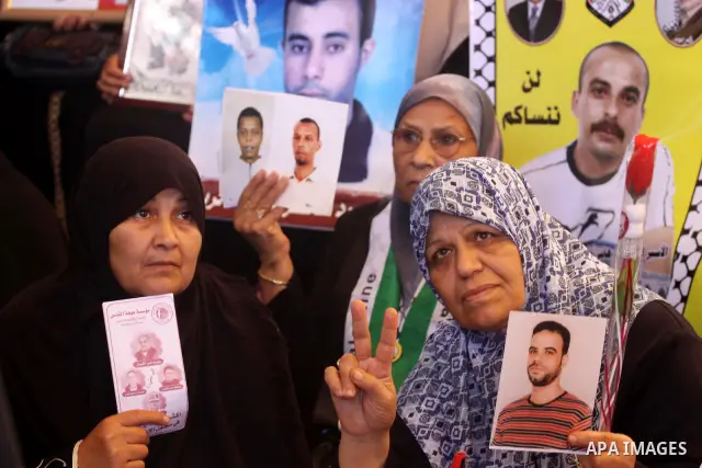 Palestinians women hold pictures of their jailed relatives during a rally, at the headquarters of the Red cross calling for the release of Palestinian prisoners from Israeli jails, in Gaza city on May 23, 2011. Photo by...