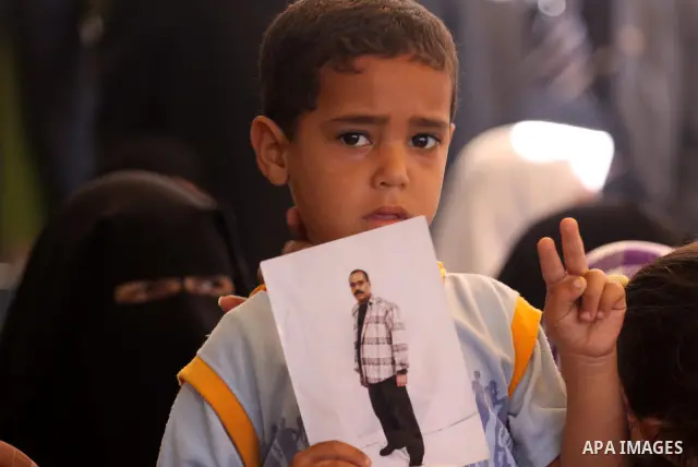 Palestinian children holds pictures of his jailed relatives during a rally, at the headquarters of the Red cross calling for the release of Palestinian prisoners from Israeli jails, in Gaza city on May 23, 2011. Photo by...