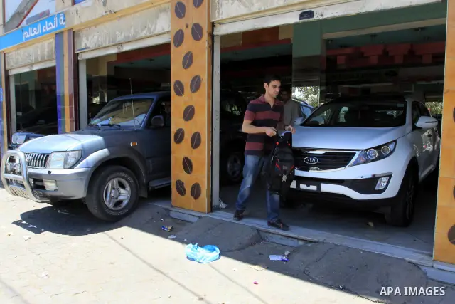 Palestinians watch a new car that Israel recently allowed into Gaza, at a showroom in Gaza City, on May 23, 2011. Luxury cars with Libyan plates are becoming a common sight in the Gaza Strip, in a surprising side-effect...