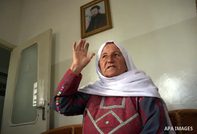 Aisha Aruri, mother of Salah Aruri (portrait top), a senior member of Hamas exiled in Syria, speaks to the press after she was released from a 24-hours Israeli detention in the West Bank city of Ramallah on May 24, 2011....
