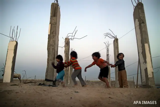 Palestinian children play outside a tent which was erected outside their family house in Jabaliya refugee camp, in the northern Gaza Strip, 24 May 2011. Their house was destroyed during the Israeli assault on Gaza in lat...