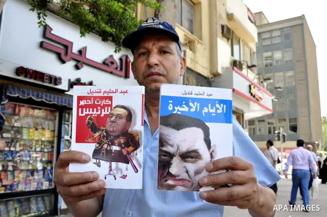 An Egyptian man looks at books and magazines with a front page picture of ousted Egyptian leader Hosni Mubarak on May 25, 2011, a day after the State prosecutor announced that Mubarak and his two sons would face trial in...