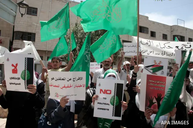 Hamas members of the Palestinian Legislative Council (PLC) take part with Palestinian supporters of the Hamas Islamist movement during a rally calling for the release of Palestinians being held in West Bank and Gaza Stri...