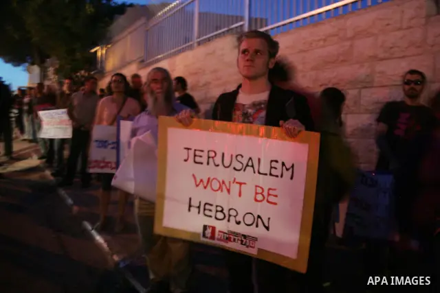 A peace activist shouts slogans while holding a sign during a demonstration by Palestinian, Israeli and foreign activists in the east Jerusalem neighbourhood of Ras al-Amud to protest against a ceremony inaugurating a ne...