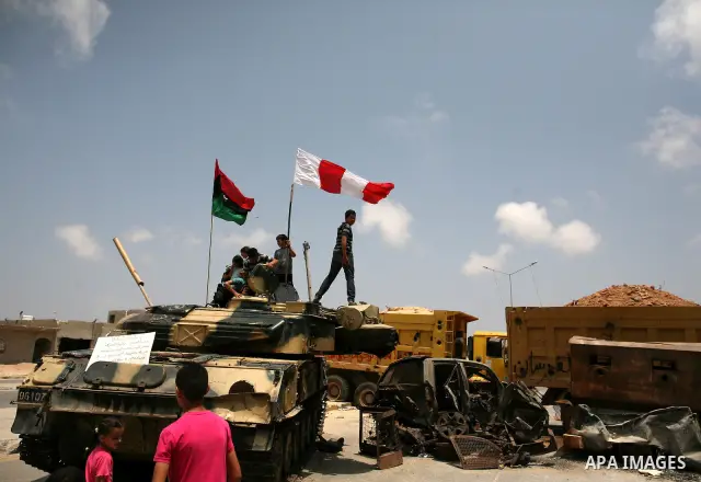 Men stand next to vehicles destroyed during clashes between rebel forces and Libyan Army loyal to leader Muammar Gaddafi in Misrata, Libya, May 26, 2011. Photo by Wissam Nassar