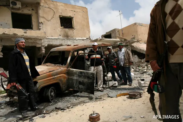 Men stand next to vehicles destroyed during clashes between rebel forces and Libyan Army loyal to leader Muammar Gaddafi in Misrata, Libya, May 26, 2011. Photo by Wissam Nassar