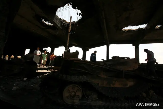 Men stand inside a building destroyed during clashes between rebel forces and Libyan Army loyal to leader Muammar Gaddafi in Misrata, Libya, May 26, 2011 Photo by Wissam Nassar
