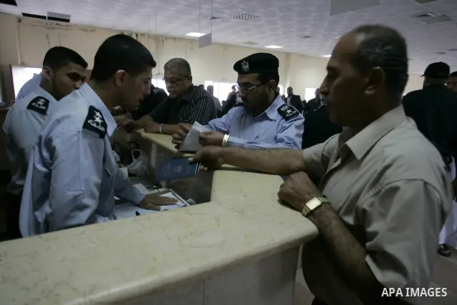 Palestinian border police check identity documents of travellers crossing into Egypt through the Rafah border crossing in the southern Gaza Strip on May 28, 2011 as Egypt reopened the border, allowing people to cross fre...