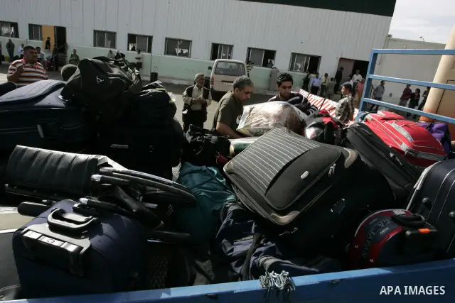 Palestinians load their luggage as they wait to cross into Egypt through the Rafah border crossing in the southern Gaza Strip on May 28, 2011 as Egypt reopened the border, allowing people to cross freely for the first ti...