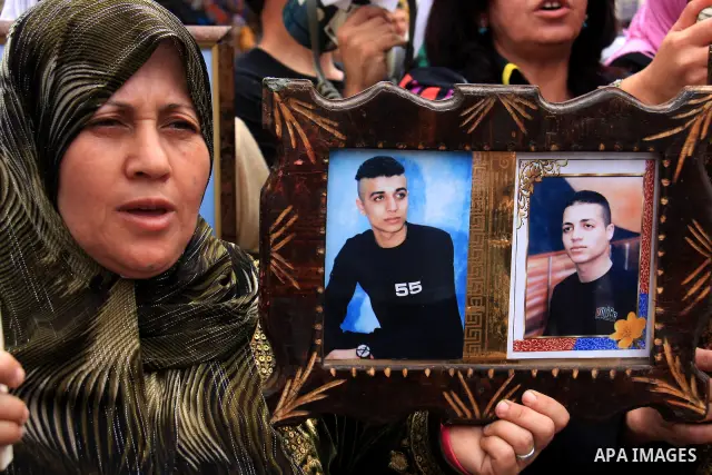 Palestinian woman holds pictures of their relatives, during a protest calling for the release of Palestinian prisoners from Israeli jails, in the West Bank city of Nablus on May 28, 2011. Israel currently holds about 8,0...