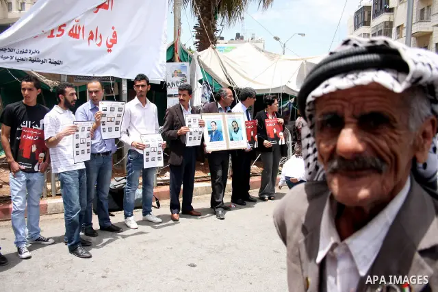 Palestinians hold banners with pictures of prisoners held in Israeli jails during a protest calling for their release, in the West Bank city of Ramallah, Saturday, May 28,2011. Photo by Issam Rimawi