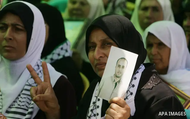 Palestinians women hold pictures of jailed relatives during a protest calling for their release from Israeli prisons near Erez crossing between Israel and the northern Gaza Strip on May 28, 2011. Photo by Yasser Fathi