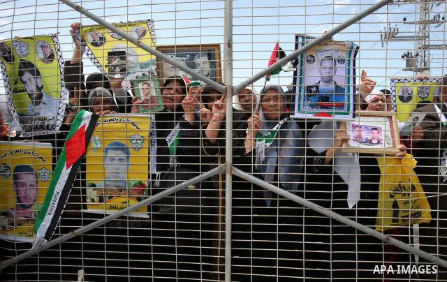 Palestinians women hold pictures of jailed relatives during a protest calling for their release from Israeli prisons near Erez crossing between Israel and the northern Gaza Strip on May 28, 2011. Photo by Yasser Fathi