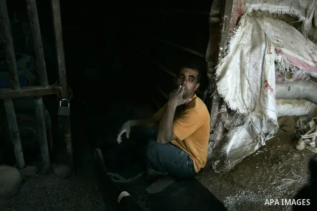 Palestinian men smuggle gravels into the Gaza Strip through a tunnel under the Egypt-Gaza border in Rafah on May 28, 2011. Egypt on Saturday reopened its Rafah border with the Gaza Strip, allowing people to cross freely...