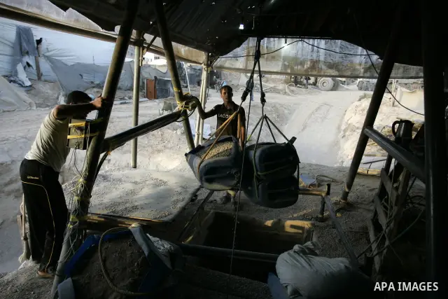 Palestinian men smuggle gravels into the Gaza Strip through a tunnel under the Egypt-Gaza border in Rafah on May 28, 2011. Egypt on Saturday reopened its Rafah border with the Gaza Strip, allowing people to cross freely...