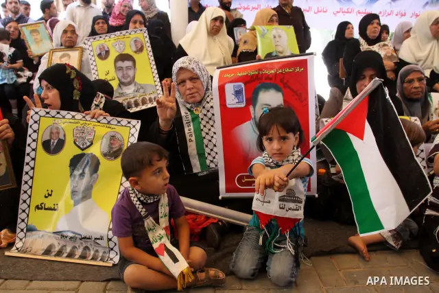 Palestinian women and children hold pictures of jailed relatives during a protest calling for the release of Palestinian prisoners from Israeli jails at the Red Cross office in Gaza City on May 30,2011. Photo by Mohammed...