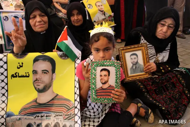 Palestinian women and children hold pictures of jailed relatives during a protest calling for the release of Palestinian prisoners from Israeli jails at the Red Cross office in Gaza City on May 30,2011. Photo by Mohammed...