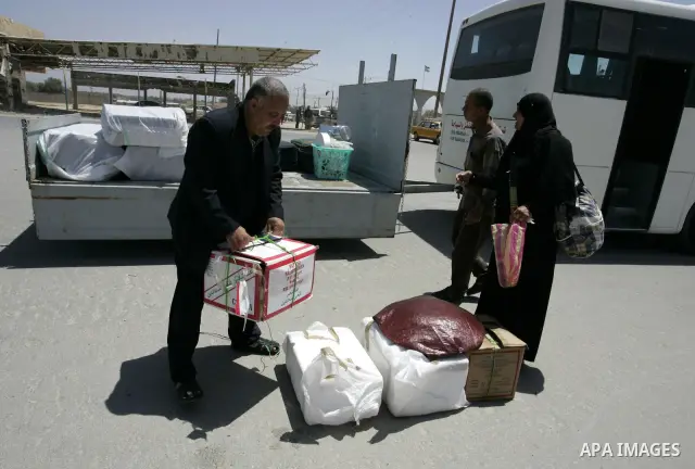 Palestinians load their luggage as they wait to cross into Egypt through the Rafah border crossing in the southern Gaza Strip on May 30, 2011. Egypt eased travel restrictions for residents of Gaza from Saturday, and erod...