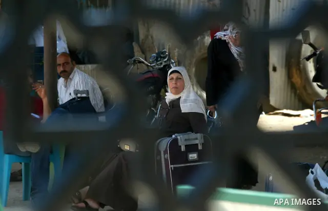 Palestinians wait to cross into Egypt through the Rafah border crossing in the southern Gaza Strip on May 30, 2011. Egypt eased travel restrictions for residents of Gaza from Saturday, and eroding a blockade that imposed...