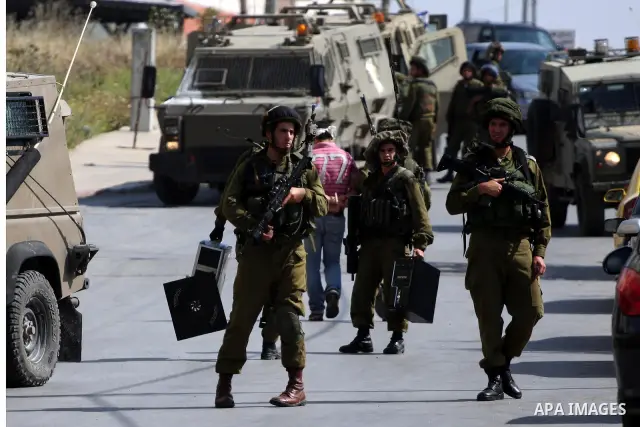 Israeli army forces carry seized computers during a raid in the West Bank city of Ramallah on May 30, 2011. Five Palestinians were arrest, three from the village of Amrine, near the northern West Bank city of Nablus and...