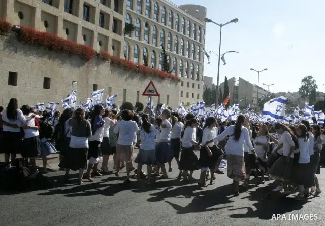 Israelis wave their national flag on July 1, 2011 as some 40,000 Jewish Israelis joined a Jerusalem Day parade in the city's mainly Arab eastern sector to celebrate its capture 44 years ago, during the Six Day War. Photo...