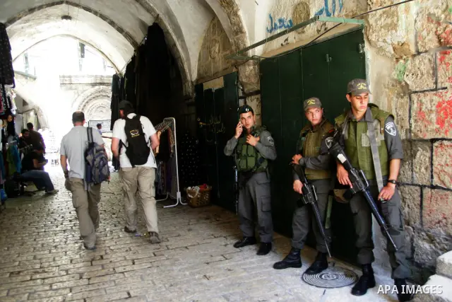 Israeli soldiers guard as Israelis march at Damascus Gate, the main entrance to the old city of Jerusalem, after they started chanting "Death to Arabs" while throwing vegetables, sticks and stones at Palestinian shopkeep...