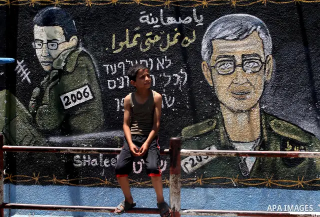 A Palestinian boy sits in front of a mural depicting captured Israeli soldier Gilad Shalit in Gaza City on June 1, 2011. in the release of the captured soldier Versus for a thousand Palestinian prisoners . Said newspaper...