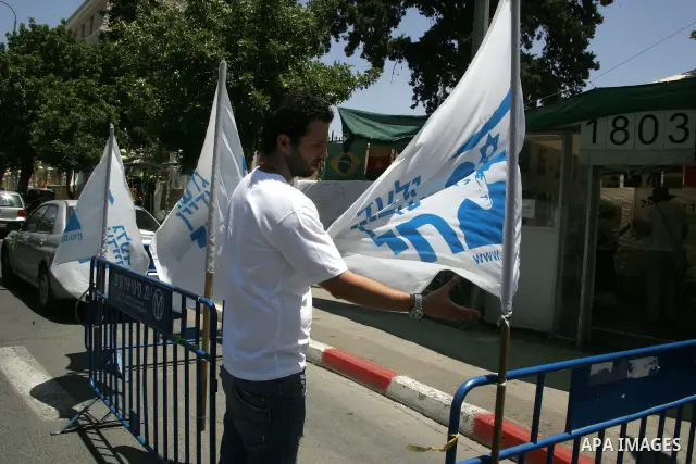 An Israeli activist holds a flag with the image of abducted Israeli soldier Gilad Shalit, next to the family's protest tent, outside Prime Minister Benjamin Netanyahu's residency in Jerusalem on June 2, 2011. Netanyahu's...