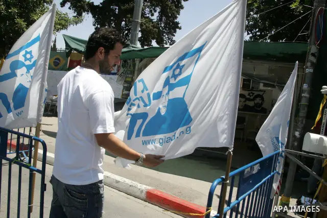 An Israeli activist holds a flag with the image of abducted Israeli soldier Gilad Shalit, next to the family's protest tent, outside Prime Minister Benjamin Netanyahu's residency in Jerusalem on June 2, 2011. Netanyahu's...