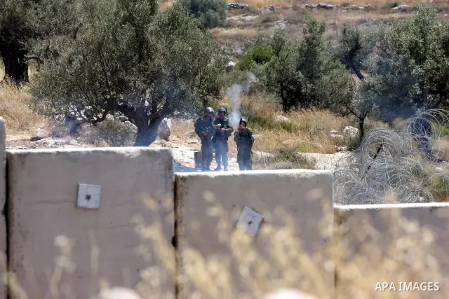 Israeli soldiers fire tear gas canisters toward Palestinian demonstrators during a protest against Israel's separation barrier in the West Bank village of Nilin, near Ramallah, Friday, June 3, 2011. Photo by Issam Rimawi
