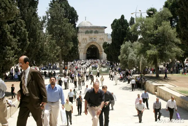 Palestinian Muslim worshipers walk in front of Al-Aqsa mosque after Friday prayer at the Al-Aqsa mosque compound in Jerusalem's Old City on June 03, 2011 as Israeli police restricted the entrance age to men over 45 at th...