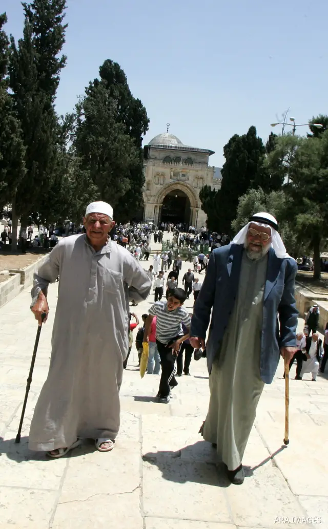 Palestinian Muslim worshipers walk in front of Al-Aqsa mosque after Friday prayer at the Al-Aqsa mosque compound in Jerusalem's Old City on June 03, 2011 as Israeli police restricted the entrance age to men over 45 at th...