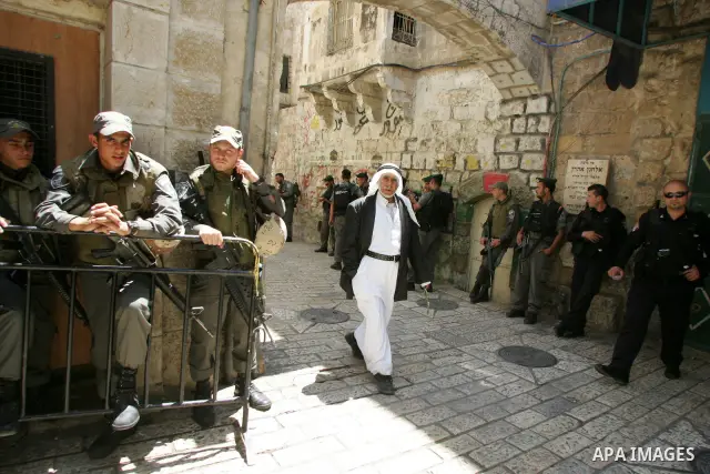 A Palestinian Muslim worshiper walk past Israeli soldiers after Friday prayer in Jerusalem's Old City on June 03, 2011 as Israeli police restricted the entrance age to men over 45 at the Al Aqsa Mosque compound in fear o...