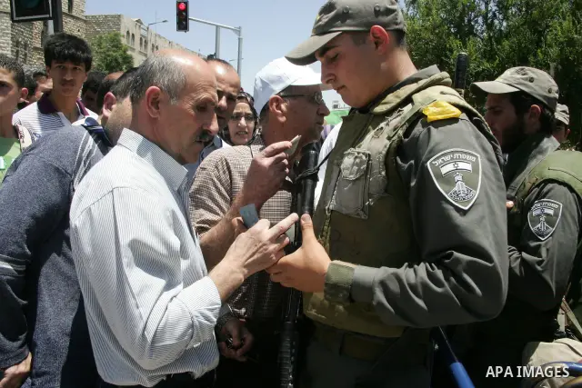 An Israeli soldier checks the identity of A Palestinian Muslim worshiper during Friday prayer in Jerusalem's Old City on June 03, 2011 as Israeli police restricted the entrance age to men over 45 at the Al Aqsa Mosque co...