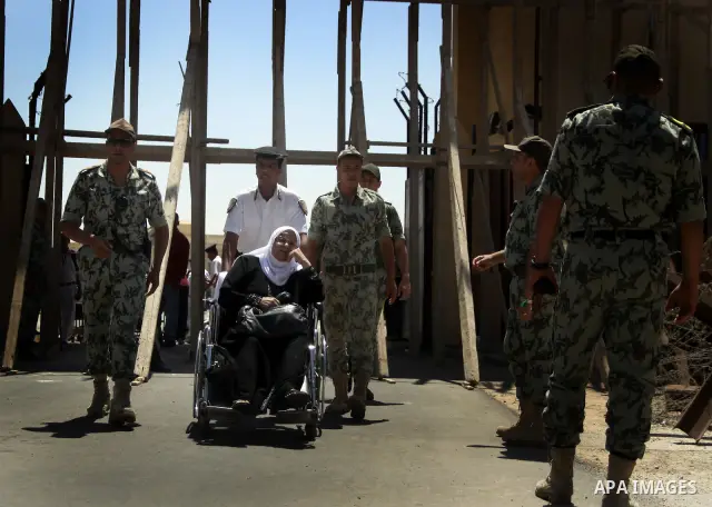 Egyptian soldiers help Palestinian passengers at the Rafah border crossing in the southern Gaza Strip 04 June 2011. Egyptian authorities reopened its Rafah border crossing with the Gaza Strip after a temporary closure wh...